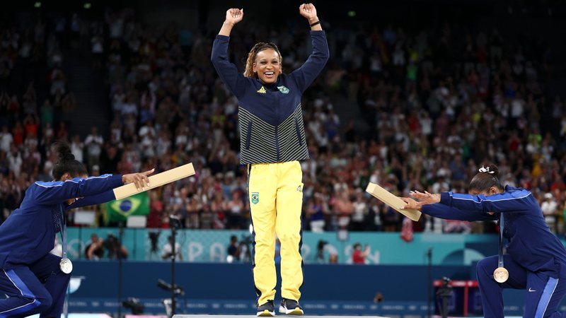 A ginasta brasileira Rebeca Andrade foi reverenciada pelas norte-americanas Simone Biles e Jordan Chiles (Foto: Naomi Baker/Getty Images)