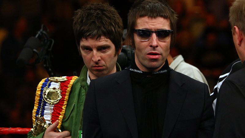 Noel e Liam Gallagher seguram o cinturão do boxeador Ricky Hatton antes de uma luta (foto: Getty/ John Gichigi)