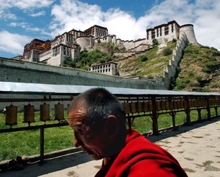 Monge caminha em Lhasa, em frente ao Palácio Potala - que já foi sede do governo tibetano - Eugene Hoshiko/AP