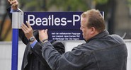 Trabalhadores terminam de pregar placas na inauguração da Beatles Platz, nesta quinta na Alemana - AP