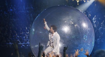 Wayne Coyne passeia pela plateia em sua indefectível esfera de plástico, que deve aparecer no clipe de "Watching The Planets" - AP