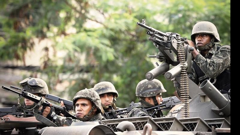 <b>FORÇA BRUTA</b> Soldados do Exército se posicionam diante do Morro do Alemão (RJ), em 27 de novembro: apesar da ofensiva, problema com o narcotráfico não deverá dimunuir - EVARISTO SA/AFP/GETTY IMAGES