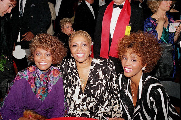 Ao lado da prima, Dionne Warwick (à esquerda), e da mãe, a cantora gospel Cissy Houston (ao centro), depois do American Music Awards, em Los Angeles, em 1987

 - AP