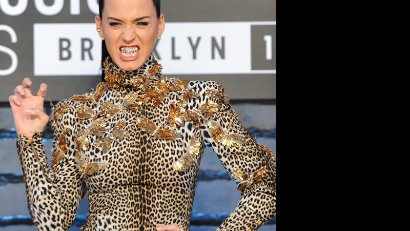 Katy Perry vestindo Emanuel Ungaro, de estampa felina combinando com o tema da música "Roar", e com uma daquelas "grelhas" douradas nos dentes - Evan Agostini/AP