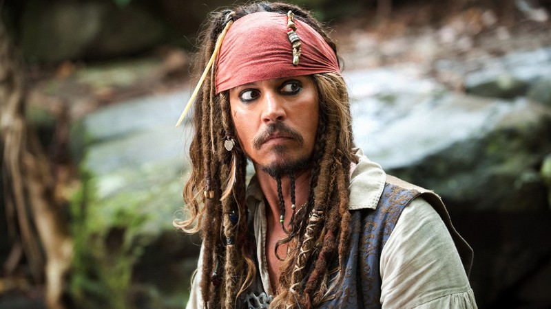 <b>Os acessórios de Jack Sparrow em <i>Piratas do Caribe</b></i>: Existe uma grande influência de Keith Richards no visual de Sparrow. A bandana e os “penduricalhos” do pirata o deixaram tão rock and roll quanto o guitarrista dos Rolling Stones.  - Reprodução