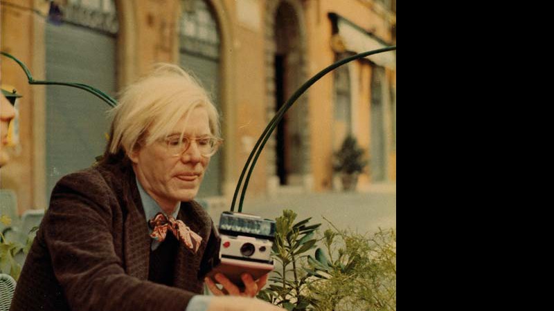 <b>REGISTRANDO</b><br>
Warhol e a companheira de todas as horas, a câmera SX-70, em 1972 - The Andy Warhol Foundation for The Visual Arts, INC.