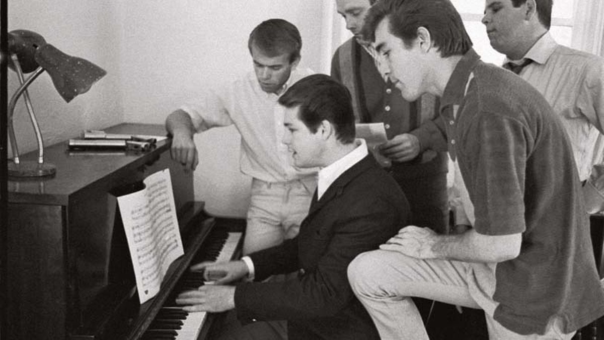 Em foto de 1964, Brian Wilson (ao piano) mostra uma nova composição para a banda. Junto a ele estão (da esq. para a dir.) Al Jardine, Mike Love, Dennis Wilson e Carl Wilson. - Divulgação