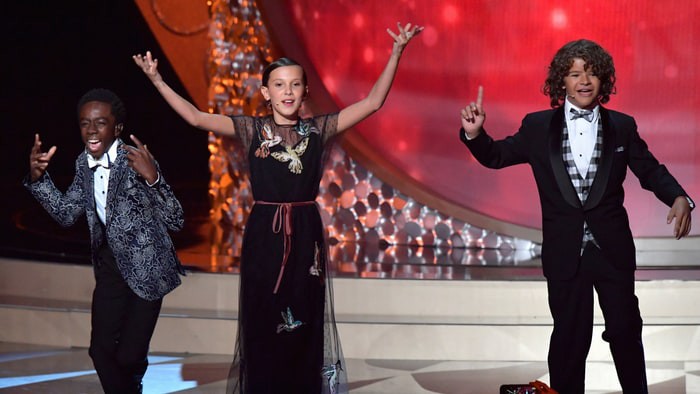 Millie Bobby Brown (Eleven), Caleb McLaughlin (Lucas) e Gaten Matarazzo (Dustin) apresentando-se no pré-show do Emmy 2016 - Lester Cohen/Getty