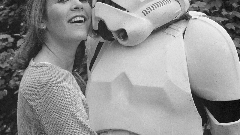 Carrie Fisher posando ao lado de um Stormtrooper em Londres, Inglaterra, no dia 23 de maio de 1980. A atriz estava na cidade divulgando o filme <i>Star Wars: Episódio V - O Império Contra-Ataca</i>. - AP