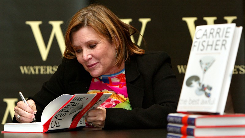 Carrie Fisher autografando seu livro <i>The Best Awful</i> em evento em Londres, Inglaterra, no dia 20 de fevereiro de 2004. A atriz e escritora é mais conhecida pelo seu bestseller internacional <i>Postcards from the Edge</i>. - AP