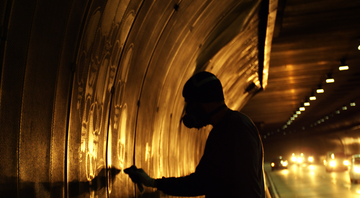 <b>Trabalho Sujo</b>
<br><bR>
Alexandre Orion durante a criação de “Ossário”. O projeto foi realizado em 2006, a partir da fuligem acumulada no túnel Max Feffer, em São Paulo - Reprodução