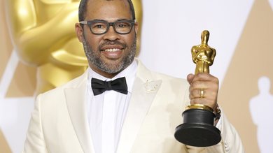 O diretor Jordan Peele com o Oscar de Melhor Roteiro Original por Corra! (Foto: Anthony Behar/Sipa USA/AP)