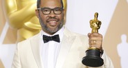 O diretor Jordan Peele com o Oscar de Melhor Roteiro Original por Corra! (Foto: Anthony Behar/Sipa USA/AP)