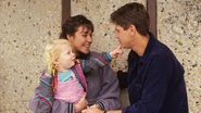 Cena de Neighbours com Miranda Fryer (no colo) e os atores Mark Little e Linda Hartley-Clark (Foto: Reprodução)