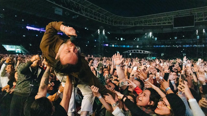 Rodrigo Amarante, dos Los Hermanos, se joga nos braços do público (Foto: Breno Galtier / Divulgação)