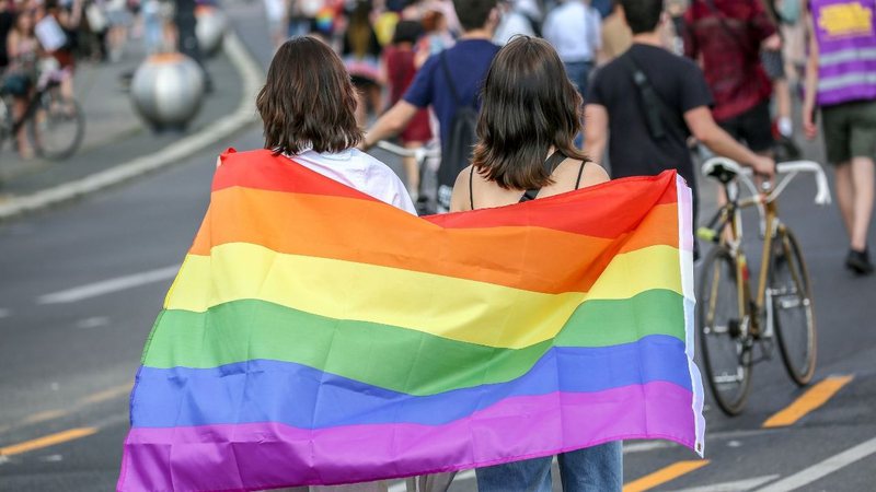 Duas mulheres com bandeira LGBTQ+ (Foto: Omer Messinger/Getty Images)