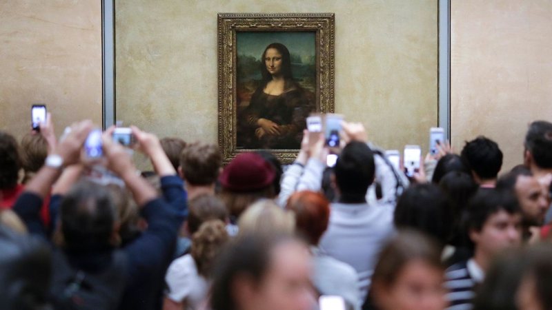 Visitantes aglomerados em frente ao quadro de Mona Lisa, no Museu do Louvre, em 2016 (Foto: AP Photo/Markus Schreiber, File)