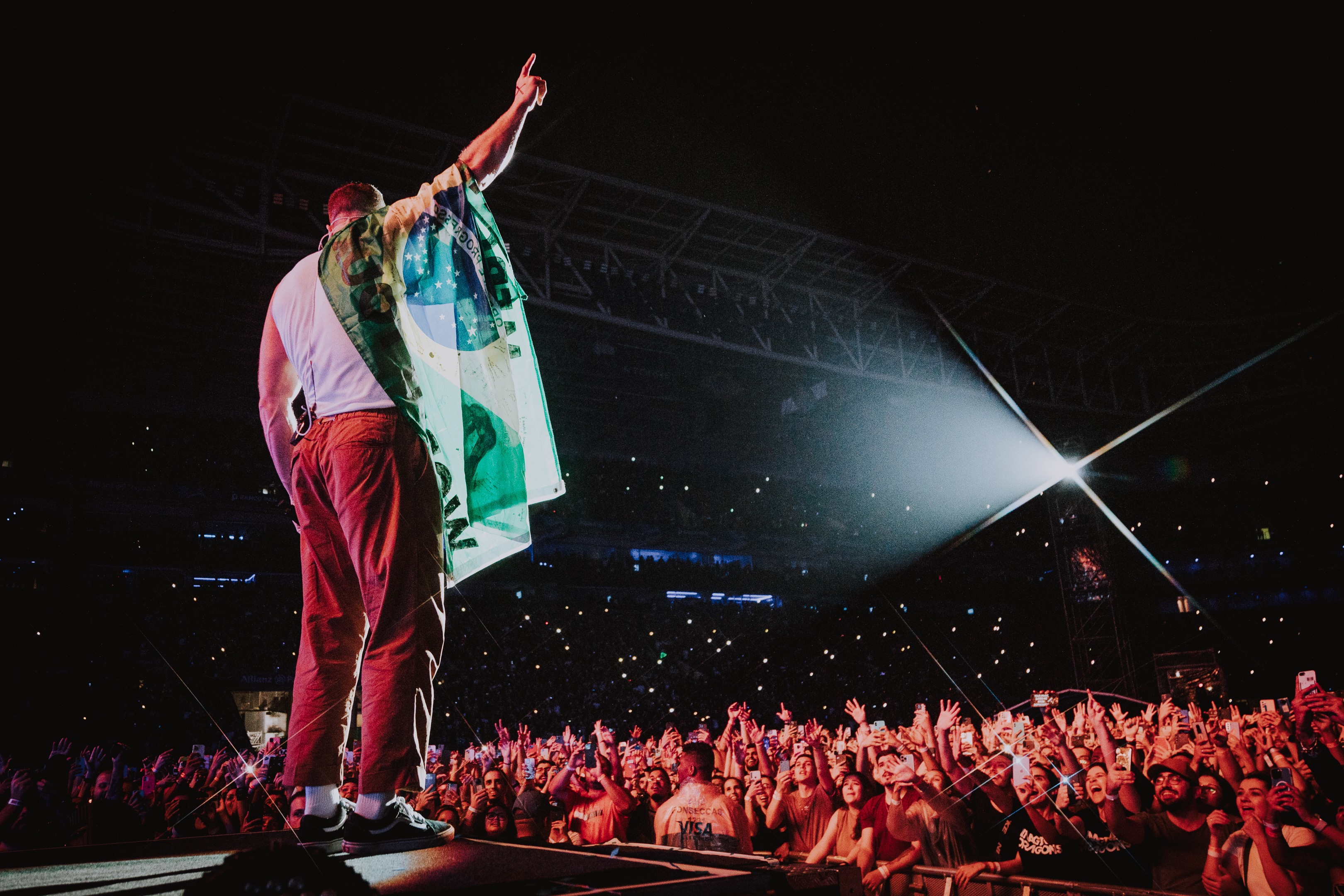Dan Reynolds com a bandeira do Brasil no ombro.