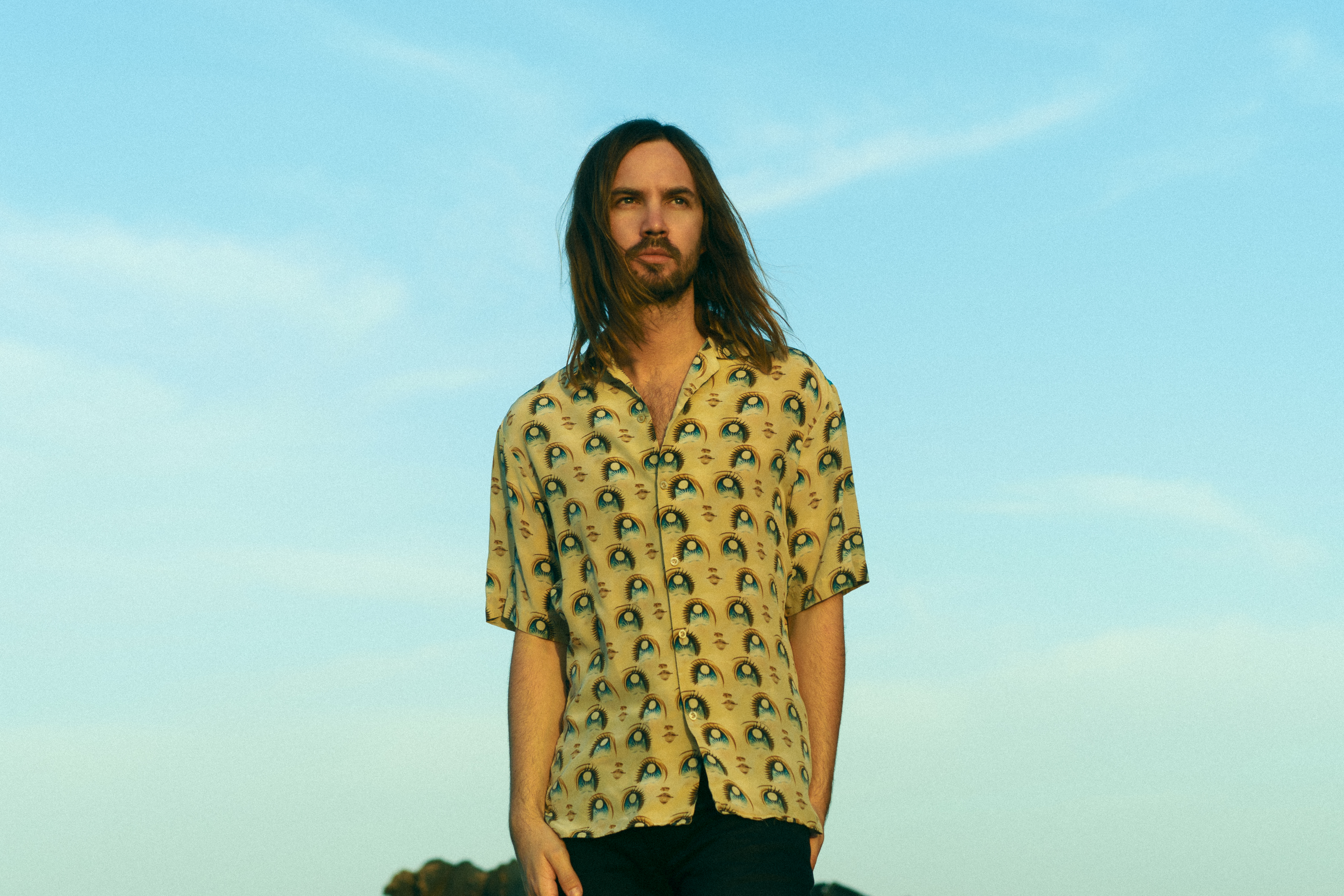 Kevin Parker com camisa verde com desenhos de olhos