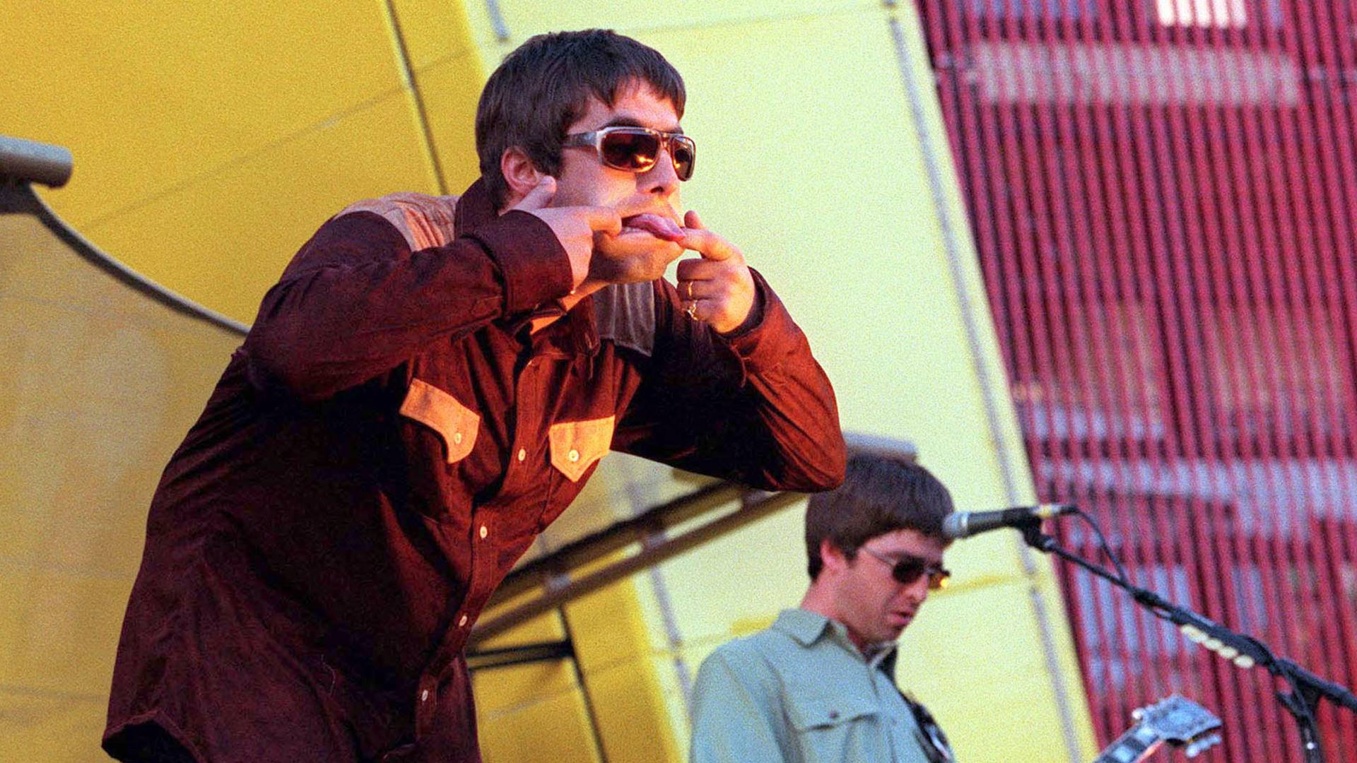 Liam e Noel Gallagher durante show do Oasis em 1997 - Foto: Dave Hogan / Getty Images