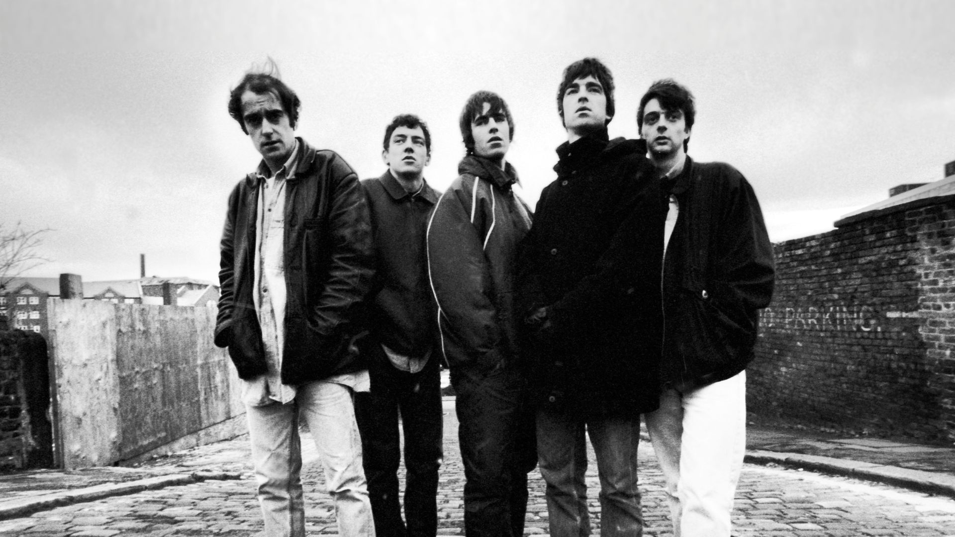 Em 1993, Oasis era formado por Paul "Bonehead" Arthurs, Tony McCarroll, Liam Gallagher, Noel Gallagher e Paul McGuigan