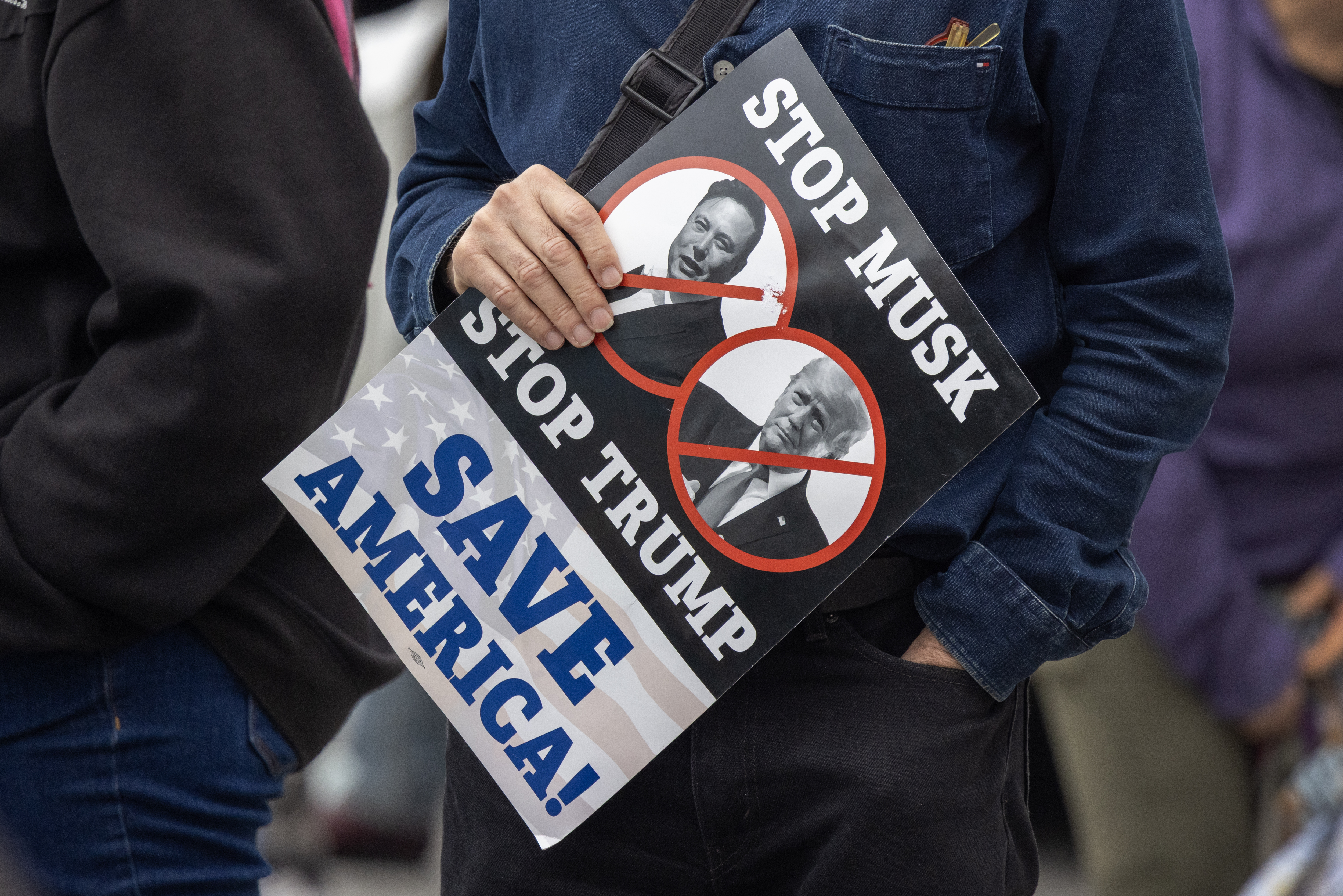 "Pare Musk, pare Trump, salve a America", diz cartaz em protesto contra o bilionário (Foto: David McNew/Getty Images)