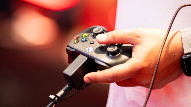 Visitante utilizando participante usa um controle do Xbox durante a Gamescom 2025