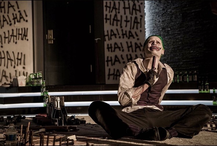 coringa de jared leto com arma apontando para o pescoço