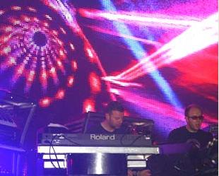 Tom Rowlands e Ed Simmons em frente às luzes por trás de seus hits