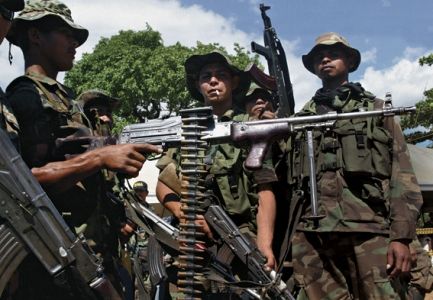 O TEATRO DE URIBE Em março de 2006, mais de 30 mil paramilitares colombianos entregaram as armas (foto). Mas a atual influência política dos neoparas prova que o movimento criminoso continua a existir