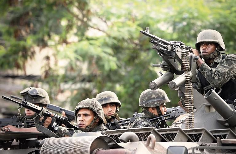 FORÇA BRUTA Soldados do Exército se posicionam diante do Morro do Alemão (RJ), em 27 de novembro: apesar da ofensiva, problema com o narcotráfico não deverá dimunuir