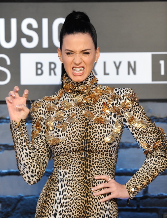 Katy Perry vestindo Emanuel Ungaro, de estampa felina combinando com o tema da música "Roar", e com uma daquelas "grelhas" douradas nos dentes