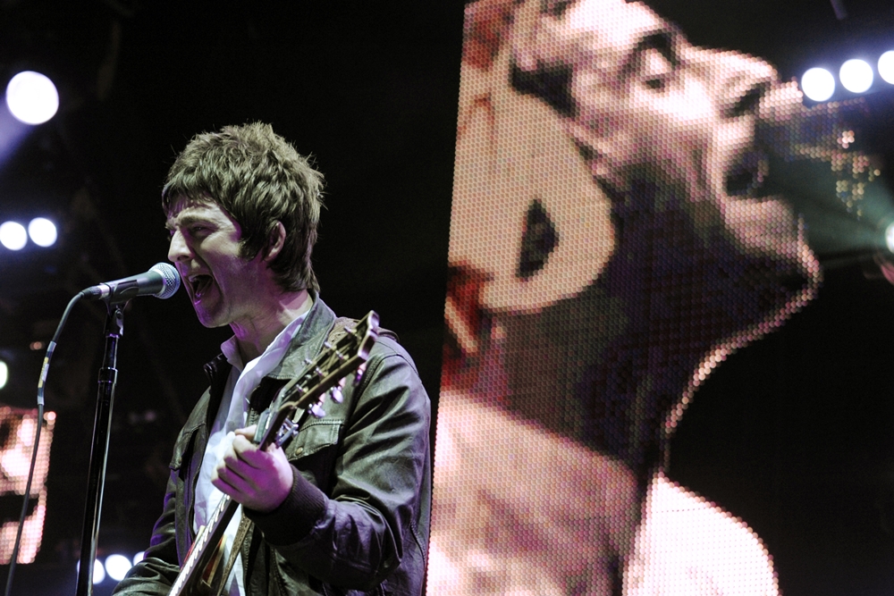 Noel Gallagher com Liam ao fundo, em um show do Oasis em 2008