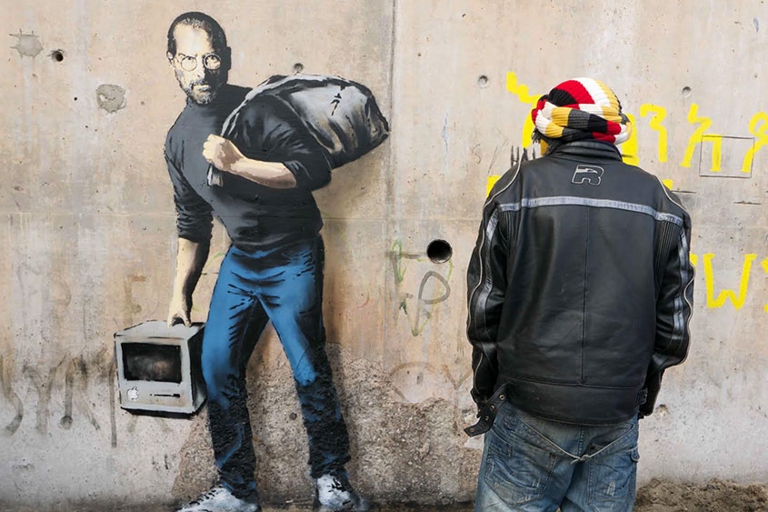 Steve Jobs retratado por Banksy como refugiado sírio