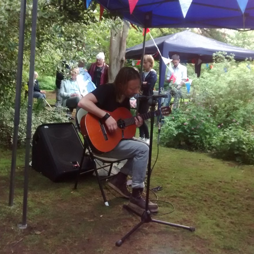 Thom Yorke, do Radiohead, tocando versões acústicas de músicas em uma festa em um jardim na vizinhança dele, em Oxford, na Inglaterra
