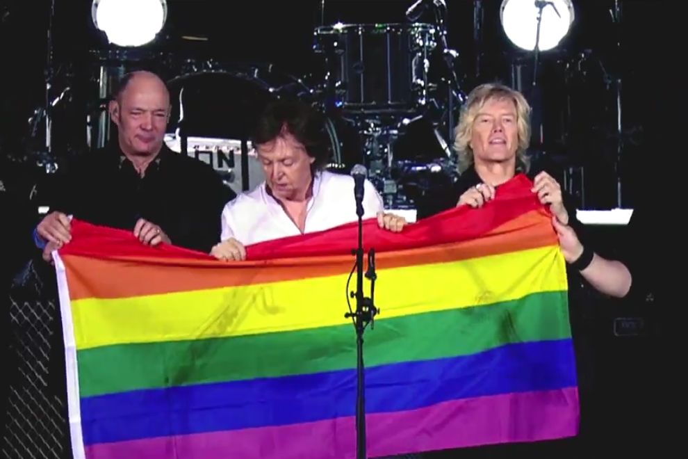 Paul McCartney durante show em Berlim, na Alemanha, segurando bandeira com arco-íris em solidariedade às vítimas do ataque a uma boate gay em Orlando