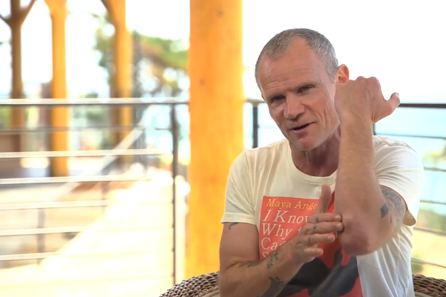 Flea, baixista do Red Hot Chili Peppers, mostrando a lesão no braso causada por um acidente enquanto ele praticava snowboarding