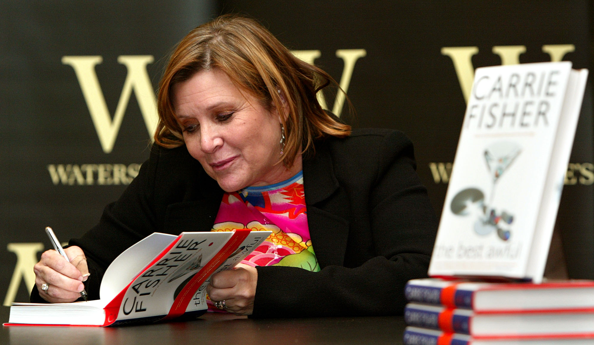 Carrie Fisher autografando seu livro The Best Awful em evento em Londres, Inglaterra, no dia 20 de fevereiro de 2004. A atriz e escritora é mais conhecida pelo seu bestseller internacional Postcards from the Edge.