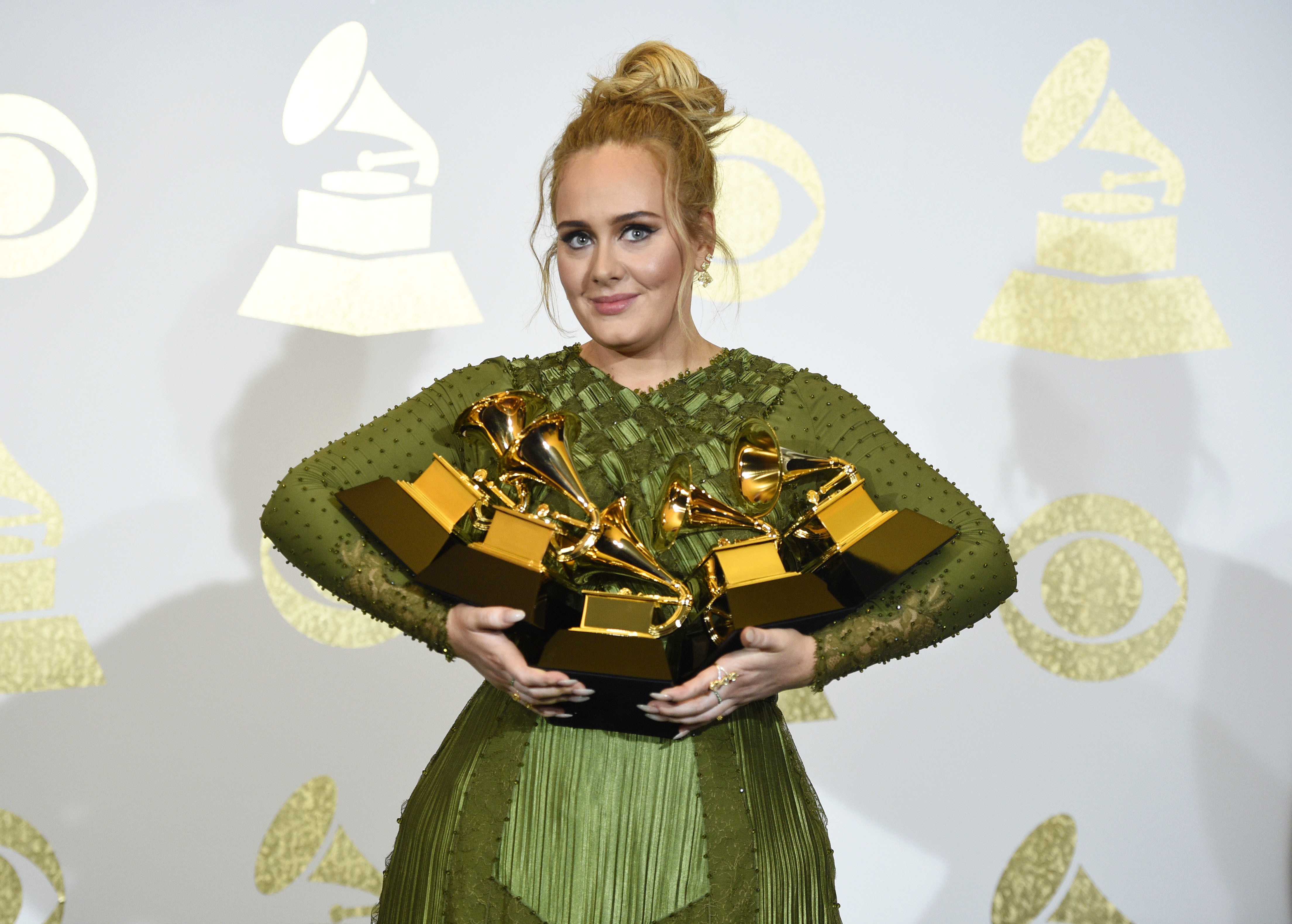 Adele exibindo os gramofones de ouro ganhados no Grammy 2017