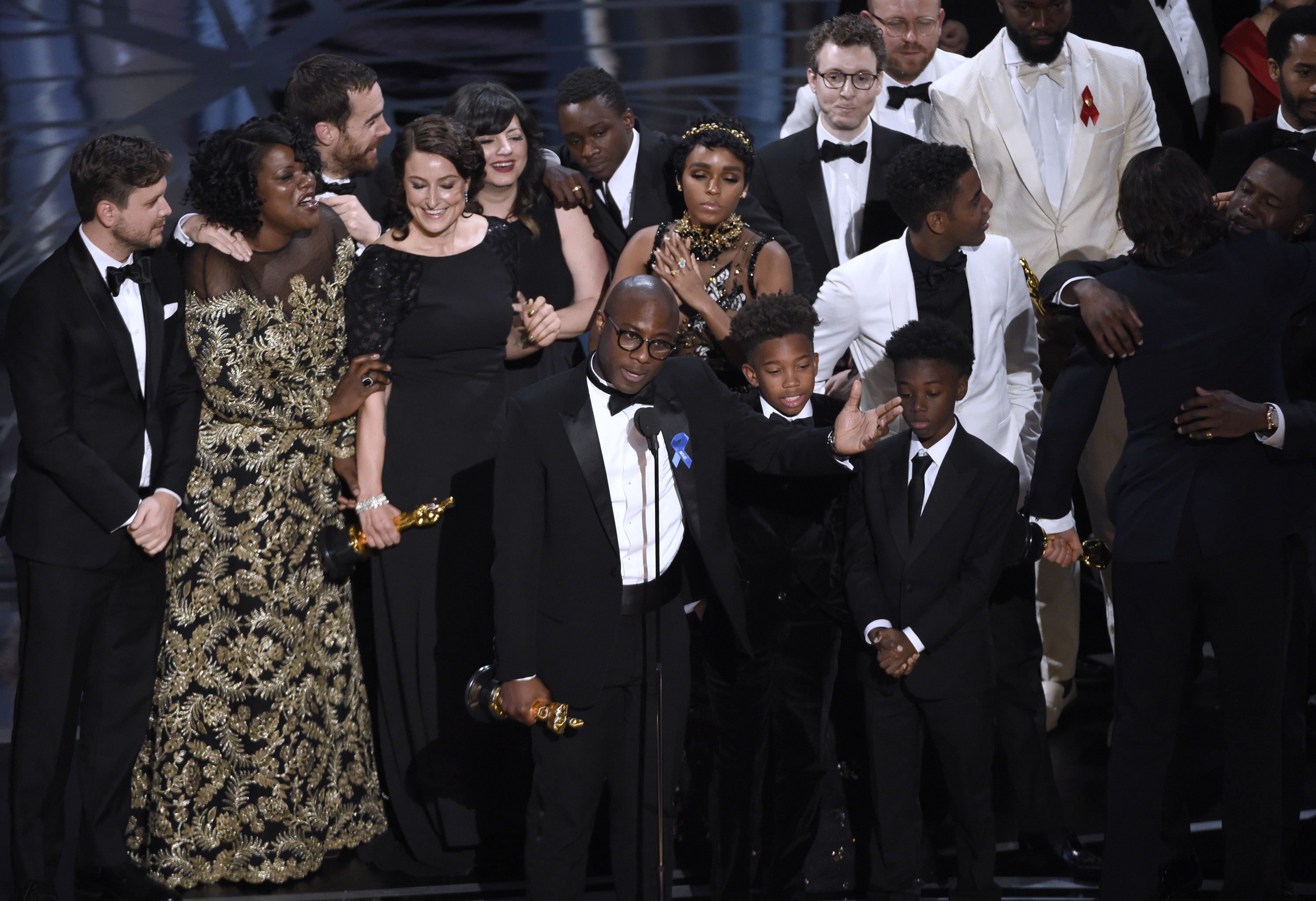 Barry Jenkins (no centro), cercado pelo elenco e equipe de Moonlight: Sob a Luz do Luar, aceitando o Oscar de Melhor Filme